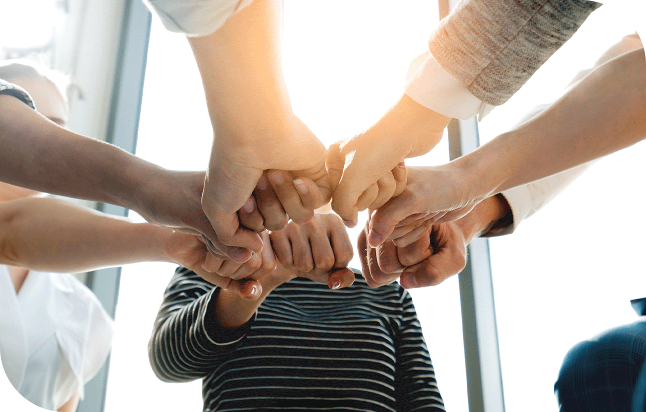 Plusieurs personnes se tenant les mains pour un cri d’équipe