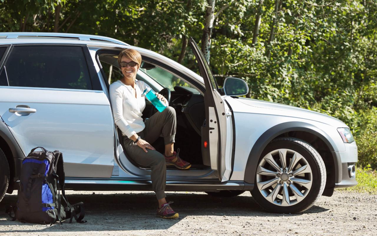 Une femme boit assise dans son auto