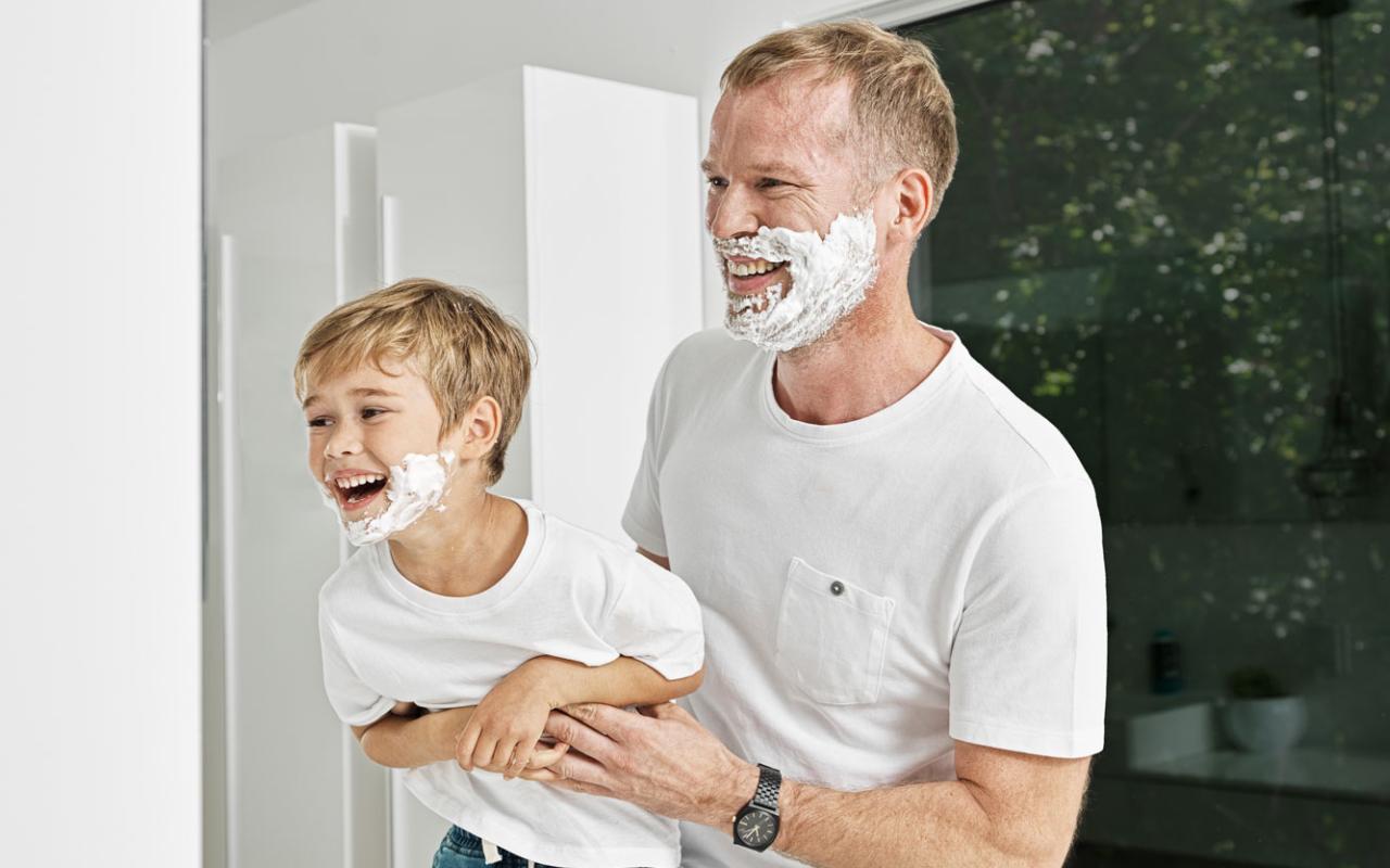 Un père et son fils jouent avec de la mousse à raser