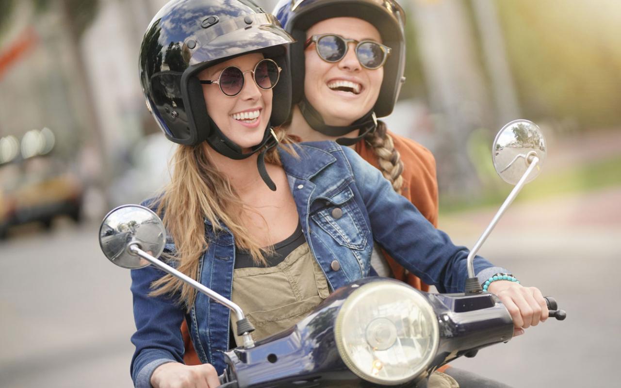 Deux jeunes femmes sur un cyclomoteur