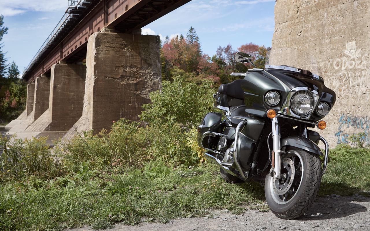 Une moto garée au pied d'un viaduc