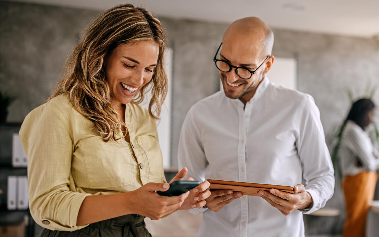 Deux personnes consultant un téléphone cellulaire