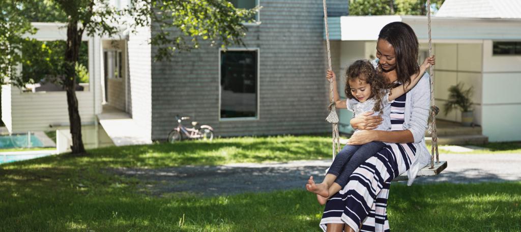 Une mère et son enfant se balancent dans un jardin
