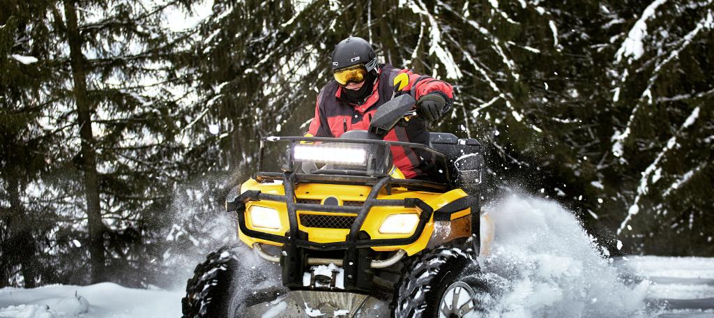 VTT en action sur un sentier enneigé en forêt au Québec