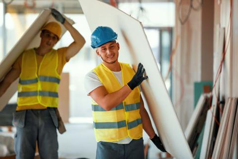 Travailleurs de la construction qui transportent des planches
