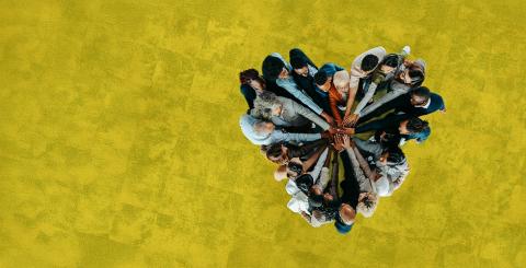 Groupe multiculturel composé d'hommes et de femmes se tenant la main à l'unisson