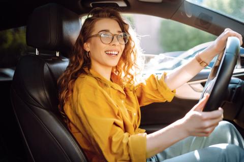 Jeune femme souriante au volant 