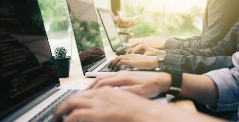 Plusieurs personnes tapant sur les claviers d'ordinateurs portables