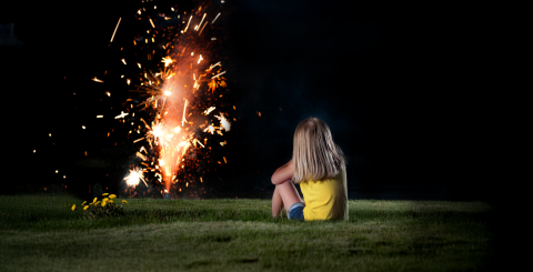 Jeune fille regardant un feux d'artifice familial dans sa cour.