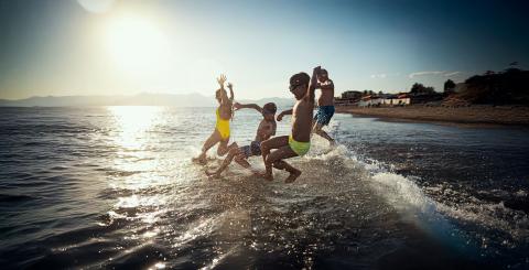 Famille se projetant dans l'eau à la plage