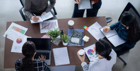 équipe dynamique de 5 personnes travaillant en table ronde