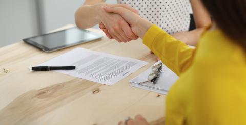 Poignée de main entre deux personnes à un bureau