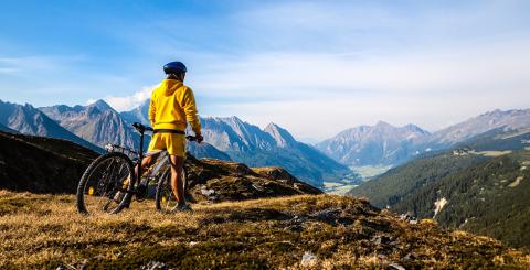 Personne en velo de montagne qui regarde le paysage