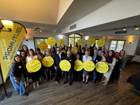 Représentants d’organismes communautaires réunis lors d’une remise de dons de Promutuel Assurance du St-Laurent aux Appalaches, tenant des panneaux jaunes affichant les montants reçus.