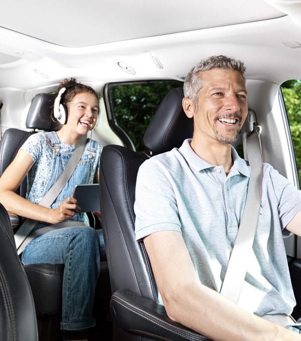 Un père et sa fille sourient dans leur auto