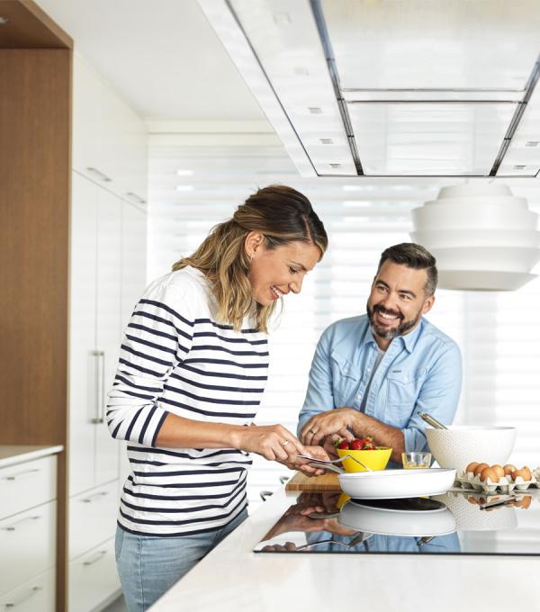 Un couple cuisine dans un appartement