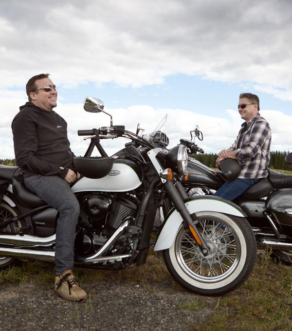 Des hommes sourient sur des motos