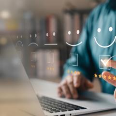 Personne sur son ordinateur inscrivant 5 étoiles à un service en ligne