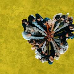 Groupe multiculturel composé d'hommes et de femmes se tenant la main à l'unisson