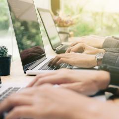 Plusieurs personnes tapant sur les claviers d'ordinateurs portables