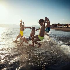 Famille se projetant dans l'eau à la plage