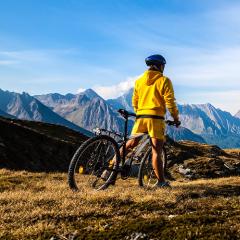 Personne en velo de montagne qui regarde le paysage