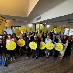 Représentants d’organismes communautaires réunis lors d’une remise de dons de Promutuel Assurance du St-Laurent aux Appalaches, tenant des panneaux jaunes affichant les montants reçus.
