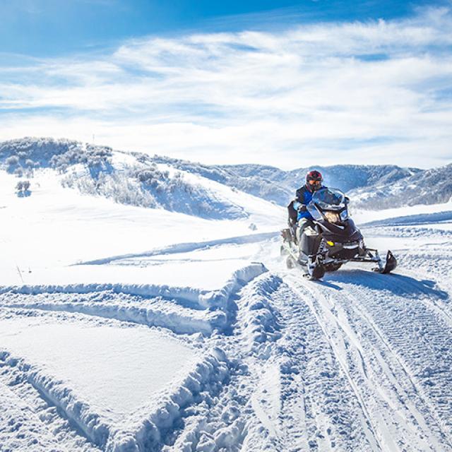 Un motoneigiste en pleine randonnée dans des montagnes enneigées