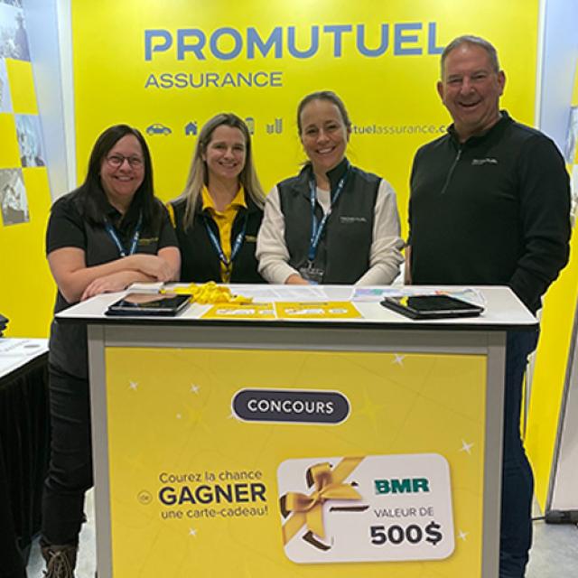 4 représentants Promutuel derrière un kiosque affichant un concours pour gagner une carte cadeau BMR de 500$