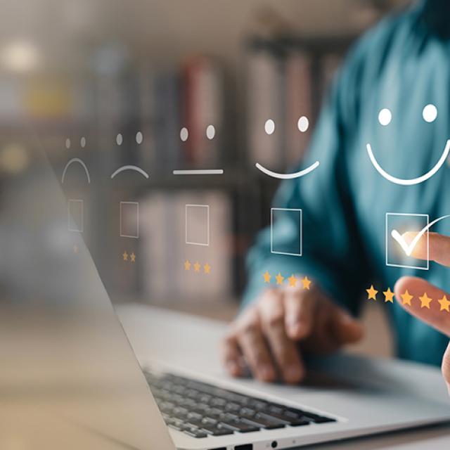 Personne sur son ordinateur inscrivant 5 étoiles à un service en ligne