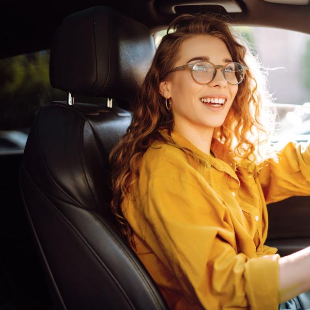 Jeune femme souriante au volant 