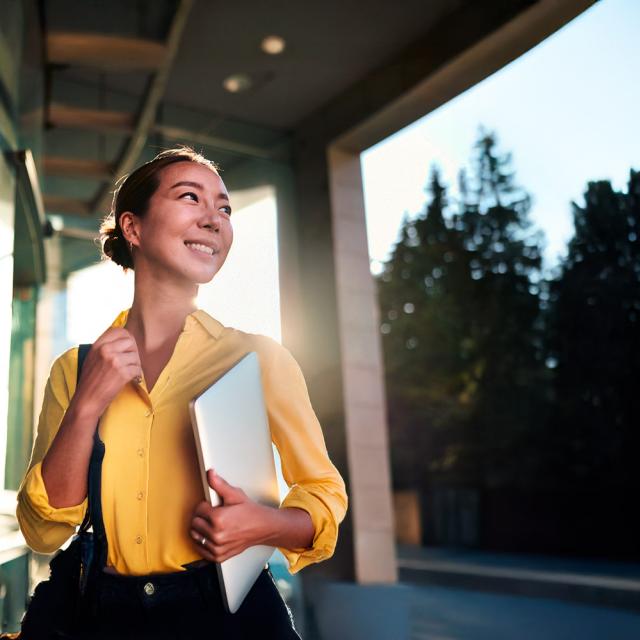 Jeune dame souriante allant travailler dans une mutuelle pour Promutuel Assurance